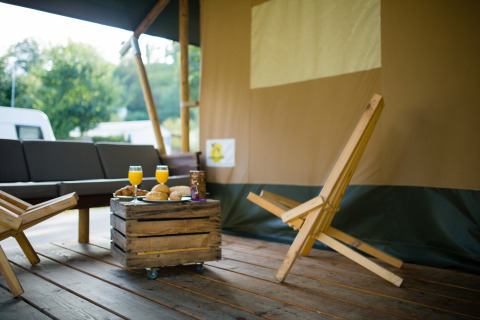 En hyggelig lodge med træmøbler og morgenmad i Safari-teltet på Camping Val d'Or, Luxembourg.