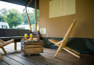 Lodge de tienda safari con muebles de madera y desayuno en Camping Val d'Or en Luxemburgo.
