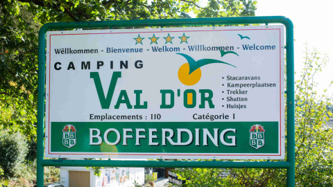 Sign at Camping Val d'Or holiday park in Wiltz, Luxembourg, showing welcome message and park facilities.