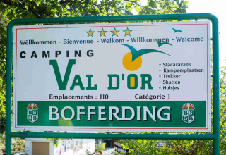 Sign at Camping Val d'Or holiday park in Wiltz, Luxembourg, showing welcome message and park facilities.