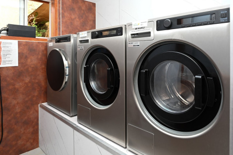 Laundry room with industrial washing machines at Camping Val d'Or holiday park in Wiltz, Luxembourg.