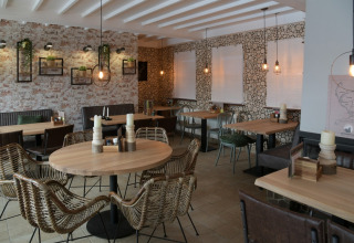 Modern and cozy restaurant at Camping Val d'Or in Wiltz, Luxembourg, featuring stylish decor and wooden furniture.