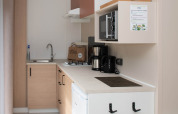 Moderne compacte keuken met apparatuur en koffiezetapparaat in een lodge op Camping Val d'Or, Luxemburg.