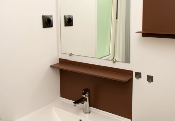 Salle de bain moderne avec lavabo blanc, miroir et étagères brunes au Tiny house du Camping Val d'Or, Luxembourg.