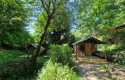 Boslodge um Bierg auf Camping Val d'Or in Luxemburg, umgeben von grüner, dichter Natur.