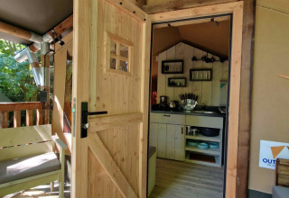 Geöffnete Holztür zu einer gemütlichen Lodge bei Boslodge um Bierg, Camping Val d'Or, Luxemburg.