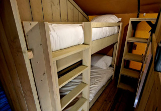 Binnenzicht van een houten stapelbed in Boslodge um Bierg op Camping Val d'Or in Luxemburg.