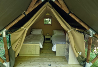 Intérieur de la Boslodge um Bierg au Camping Val d'Or, Luxembourg : deux lits simples dans une tente.