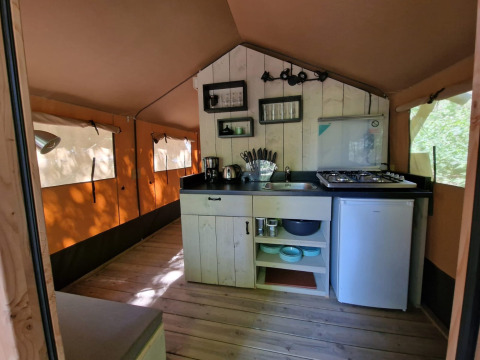 Coin cuisine rustique dans la Boslodge um Bierg au Camping Val d'Or, Luxembourg, avec évier et réfrigérateur.
