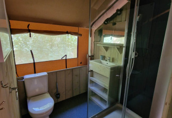 Bathroom at Boslodge um Bierg, Camping Val d'Or, Luxembourg, featuring a toilet, shower, and a small sink.