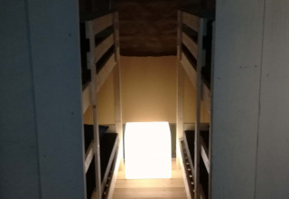 Ingang van een safaritent bij Camping Val d'Or in Luxemburg met stapelbedden en een lichtgevende kubus.