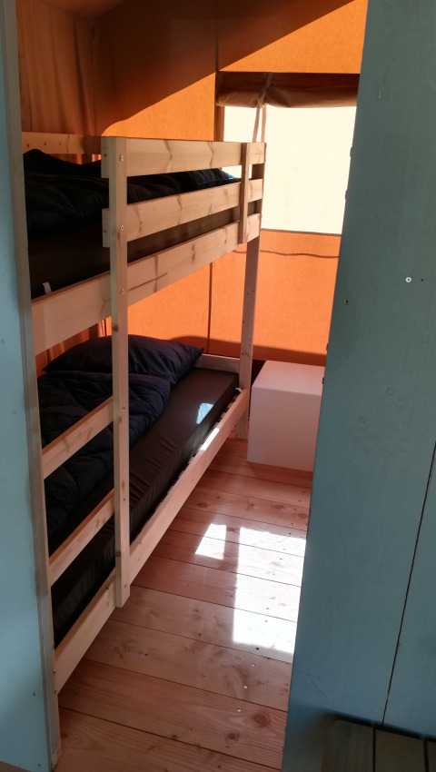 Ein Zimmer mit Etagenbett und Holzboden in einem Safari-Zelt-Lodge auf Camping Val d'Or in Luxemburg.