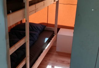 Habitación con literas y suelo de madera en una tienda safari en Camping Val d'Or en Luxemburgo.