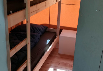 Stanza con letto a castello e pavimento in legno in una tenda safari al Camping Val d'Or in Lussemburgo.