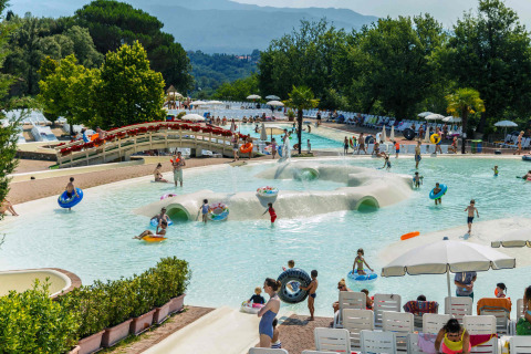 Kinderen en families spelen in het zwembad van hu Norcenni Girasole Village vakantiepark in Toscane, Italië.
