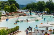 Families and children swim and play at the pool of hu Norcenni Girasole Village holiday park in Tuscany, Italy.