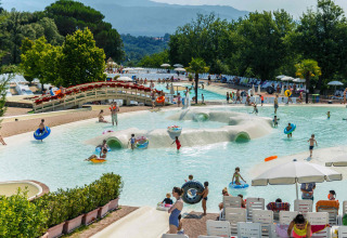 Kinderen en families spelen in het zwembad van hu Norcenni Girasole Village vakantiepark in Toscane, Italië.