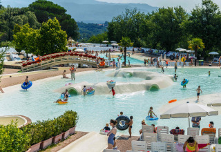 Families and children swim and play at the pool of hu Norcenni Girasole Village holiday park in Tuscany, Italy.