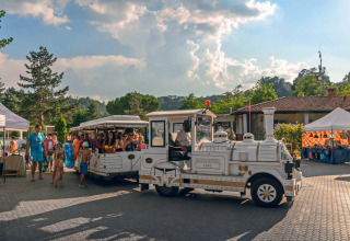 Toeristisch treintje brengt gezinnen door hu Norcenni Girasole Village in Toscane, Italië.