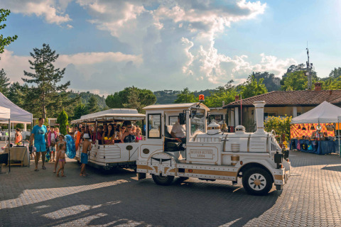 Toeristisch treintje brengt gezinnen door hu Norcenni Girasole Village in Toscane, Italië.