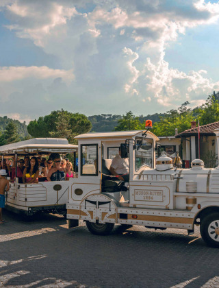Tren turístico con familias disfrutando en hu Norcenni Girasole Village, Toscana, Italia en verano.