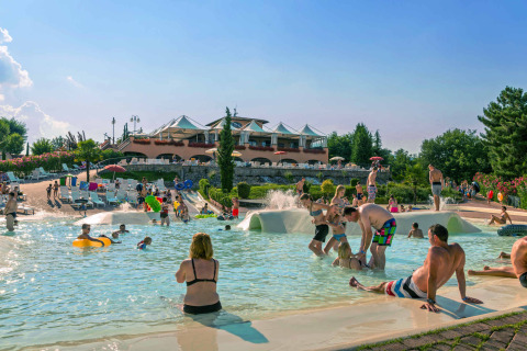 Parque vacacional en la Toscana con personas disfrutando de la piscina al aire libre en hu Norcenni Girasole Village.