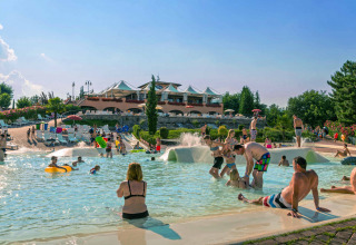 Feriepark i Toscana med mennesker, der nyder udendørs pool og solbadning på hu Norcenni Girasole Village.