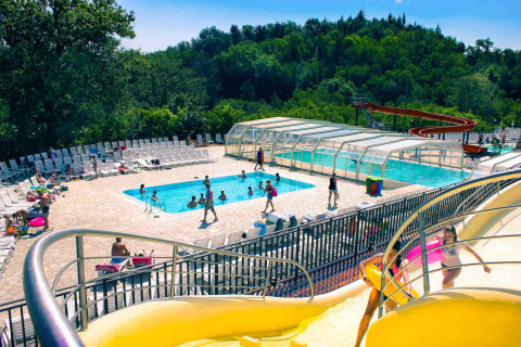 Piscina al aire libre con tobogán de agua y tumbonas en hu Norcenni Girasole Village, Toscana, Italia.