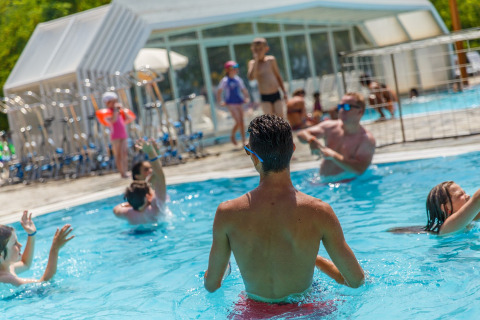 Personas divirtiéndose y nadando en la piscina del hu Norcenni Girasole Village en Toscana, Italia.