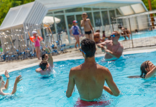 Persone che si divertono in piscina al hu Norcenni Girasole Village, Toscana, Italia, atmosfera vacanziera.