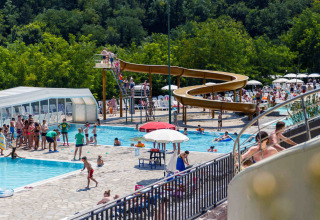 Persone che si divertono in piscina e sullo scivolo al villaggio hu Norcenni Girasole in Toscana, Italia.