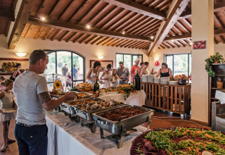 Buffet al hu Norcenni Girasole Village, villaggio turistico in Toscana, Italia, con ospiti che si servono.