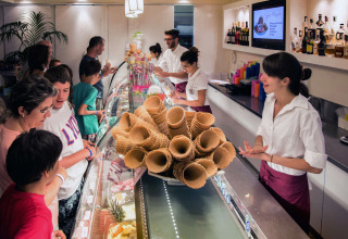 Clienti scelgono il gelato al bancone di hu Norcenni Girasole Village, un villaggio vacanze in Toscana.