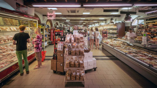 Supermercado en hu Norcenni Girasole Village, Toscana, Italia, con mostradores de charcutería y clientes.