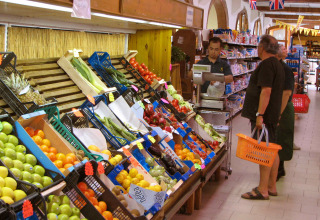 Persone fanno la spesa di frutta e verdura fresca in un supermercato al hu Norcenni Girasole Village in Toscana, Italia.