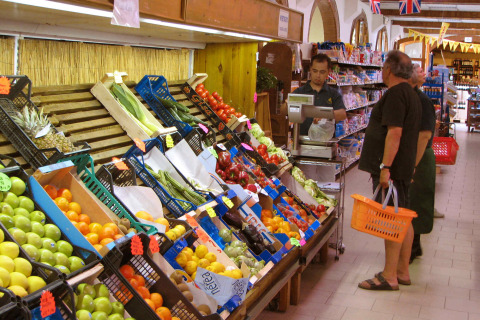 Personas comprando frutas y verduras frescas en un supermercado de hu Norcenni Girasole Village en la Toscana, Italia.