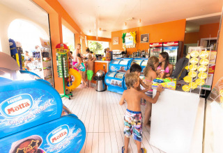 Niños en bañador comprando helados y aperitivos en hu Norcenni Girasole Village, parque de vacaciones en Toscana, Italia.