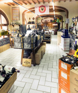 Tienda de vinos en hu Norcenni Girasole Village, Toscana, Italia, repleta de estantes y cajas con botellas de vino.