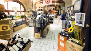 Tienda de vinos en hu Norcenni Girasole Village, Toscana, Italia, repleta de estantes y cajas con botellas de vino.