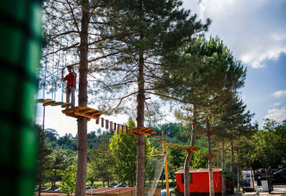 Persona su un percorso avventura tra gli alberi al hu Norcenni Girasole Village, Toscana, Italia.