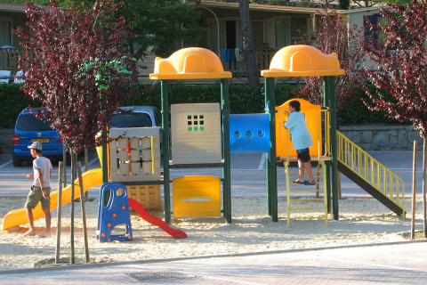 Niños y adultos jugando en el parque infantil del hu Norcenni Girasole Village en la Toscana, Italia.