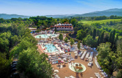Luchtzicht op Norcenni Girasole Village in Toscane met zwembaden, ligzetels en veel groen.