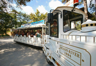 A tourist train with happy passengers at Camping Village Mare Pineta holiday park, Friuli-Venezia Giulia, Italy.