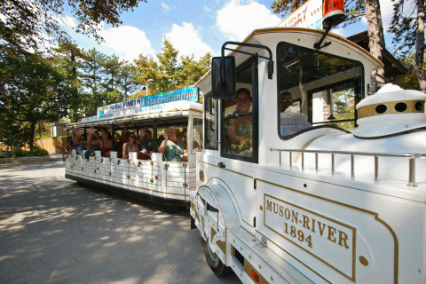 Trenino turistico con passeggeri felici al Camping Village Mare Pineta, Friuli-Venezia Giulia, Italia.