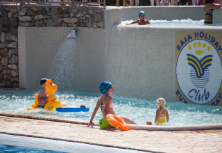 Children and adults enjoy the pool area at Camping Village Mare Pineta in Friuli-Venezia Giulia, Italy.