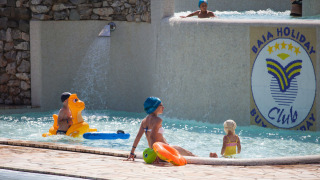 Niños y adultos disfrutan de la piscina en Camping Village Mare Pineta en Friuli-Venezia Giulia, Italia.
