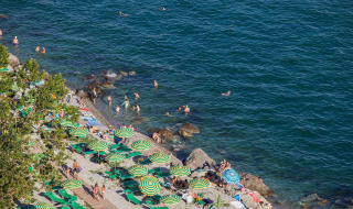 Playa con sombrillas verdes y amarillas en Camping Village Mare Pineta, Friuli-Venezia Giulia, Italia.