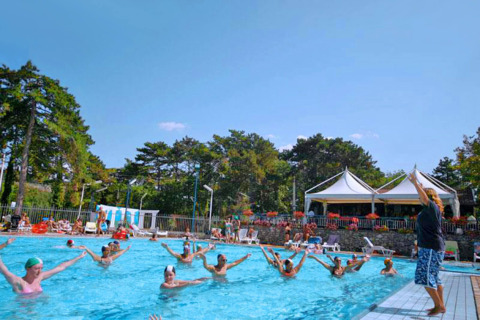 Aquagym en la piscina de Camping Village Mare Pineta, Friuli-Venezia Giulia, Italia, personas haciendo ejercicio.