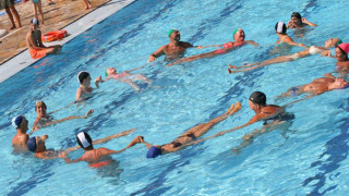Niños y adultos juegan juntos en la piscina de Camping Village Mare Pineta en Friuli-Venezia Giulia, Italia.