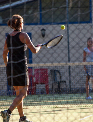 Dos personas jugando al tenis en una pista en Camping Village Mare Pineta, Friuli-Venezia Giulia, Italia.